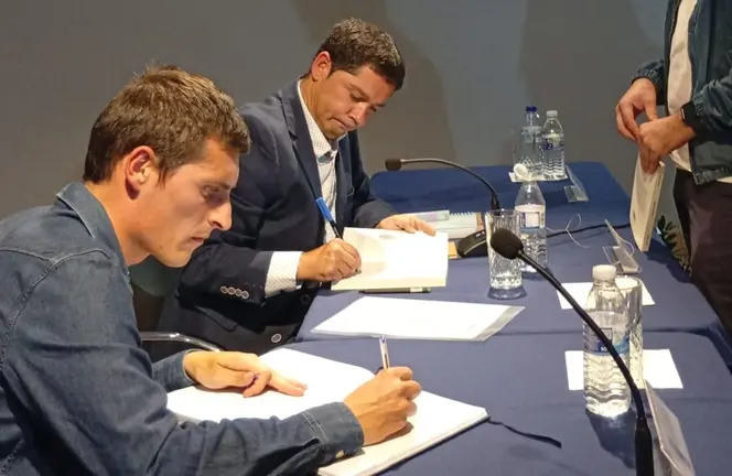 Moesto Fraga asinando libros xunto ao alcalde de Fisterra