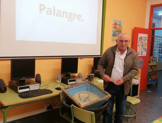Genaro Campos achegando o palangre ao ceip Vilarmide