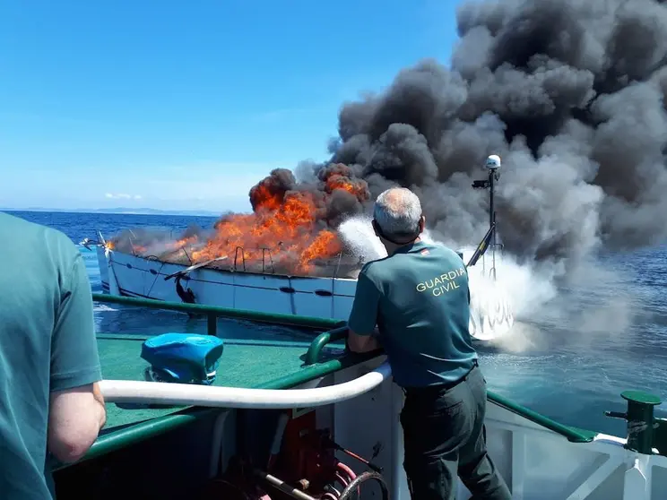 A Garda Civil sufocando un incendio preto dunha embarcacion de Malpica