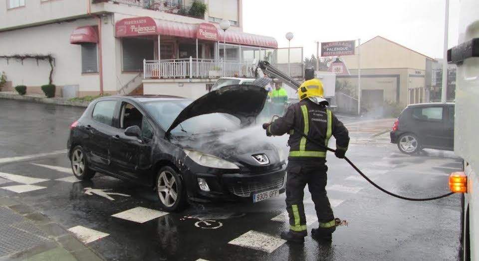 Os Bombeiros de Carballo refixerando un coche incendiado