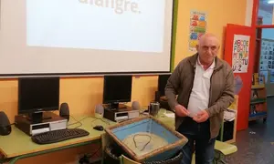 Genaro Campos achegando o palangre ao ceip Vilarmide