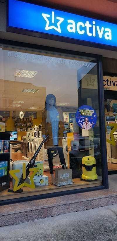 Un maniqui con roupa no escaparate dunha tenda de electrodomesticos en Baio