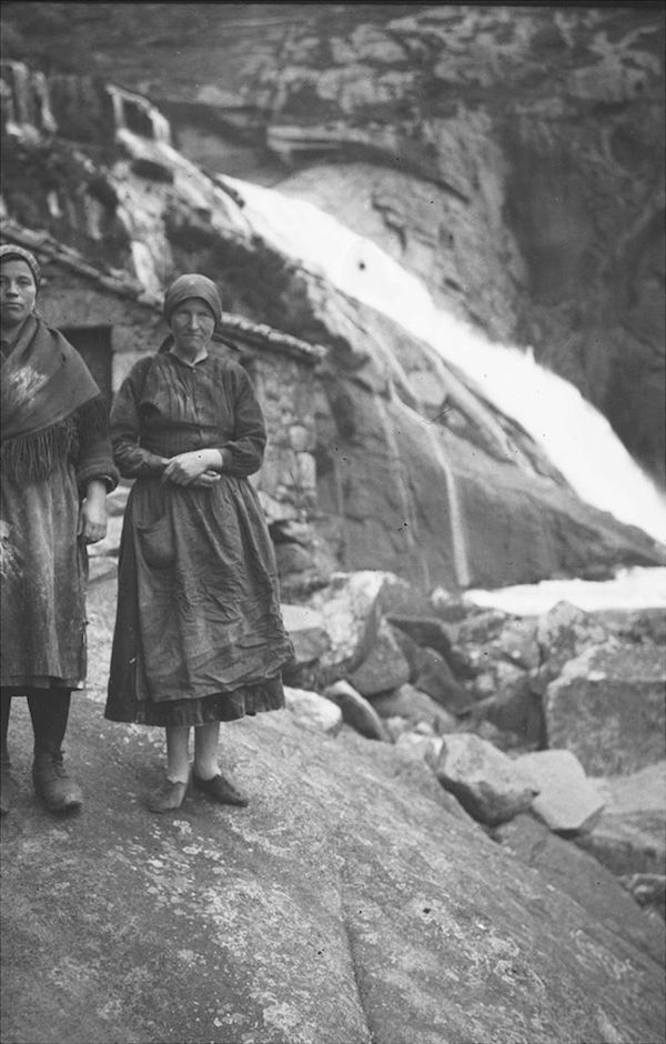 Dúas paisanas cos muíños e a fervenza do Ézaro en profundidade de campo. Arquivo do Reino de Galicia. Ca. 1924