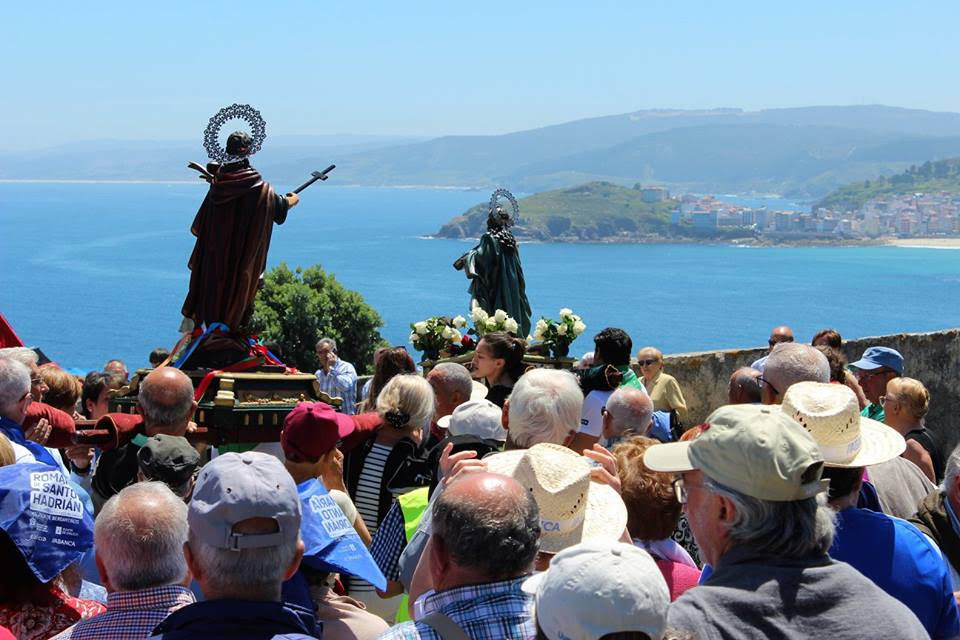 Santo Hadrián e Santa Natalia no adro da capela observando a vila de Malpica