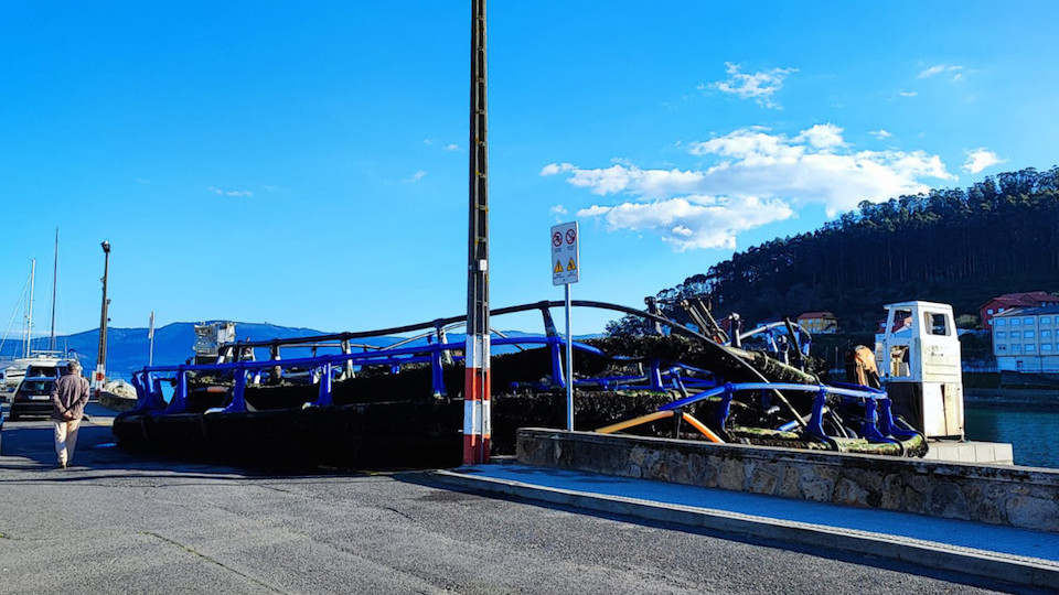 Xaulas de salmon desfeitas no porto de Muros