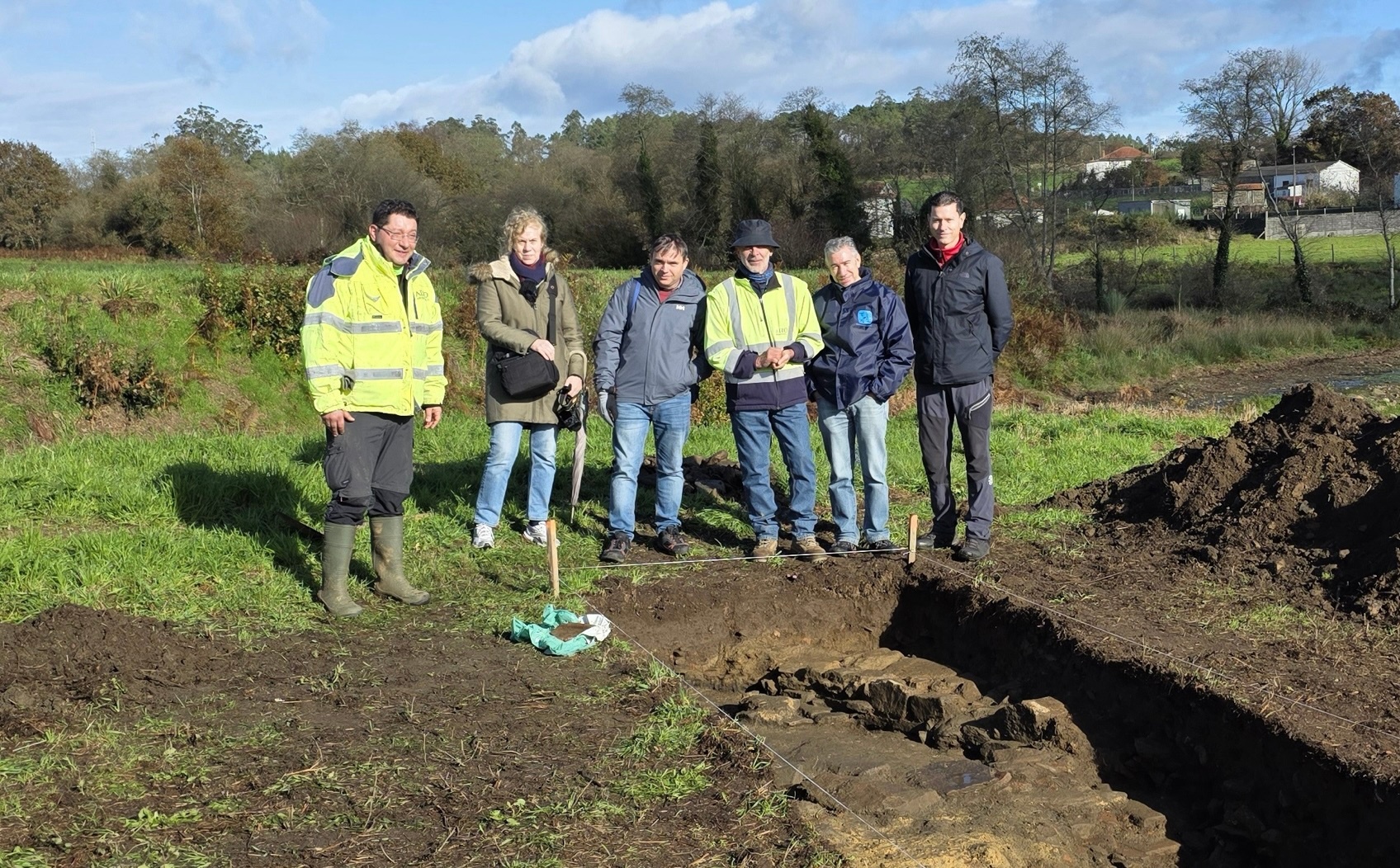 écnicos da Dirección Xeral de Patrimonio cos arqueólogos e o secretario xeral da Fundación Brandomil enfronte dunha das sondaxes